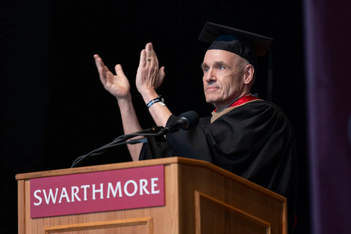 Koof Kalkstein claps while standing at podium