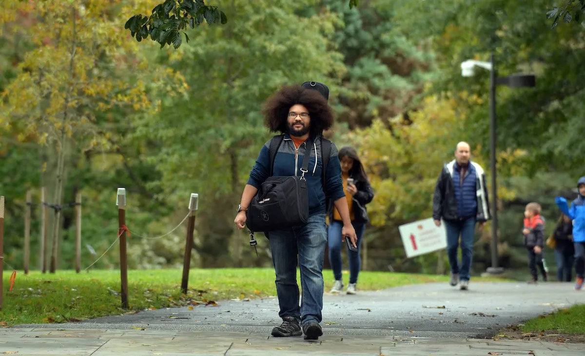 A man with bags crosses campus