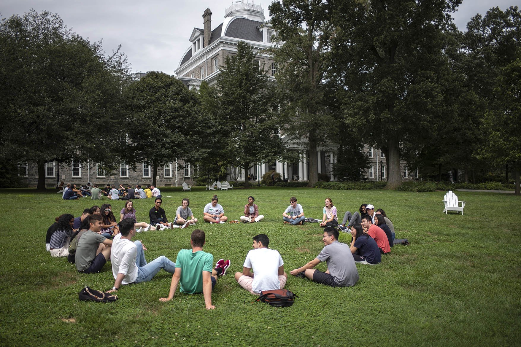 students in a circle on the grass in front of parrish hall