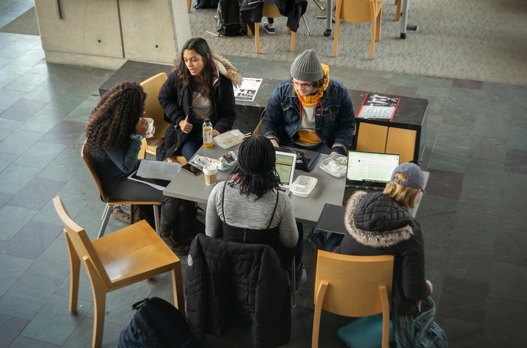 students gathered around table in study and conversation