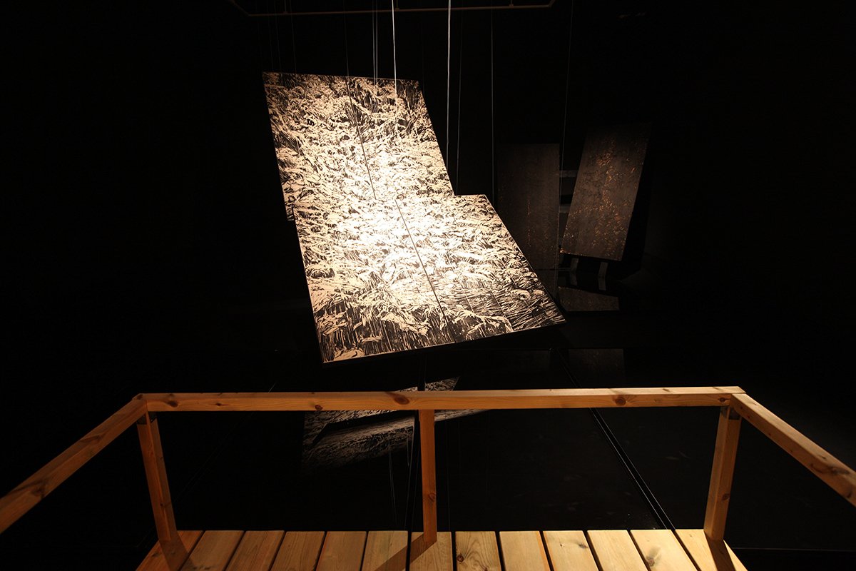 Wooden sculpture suspended in air against black background