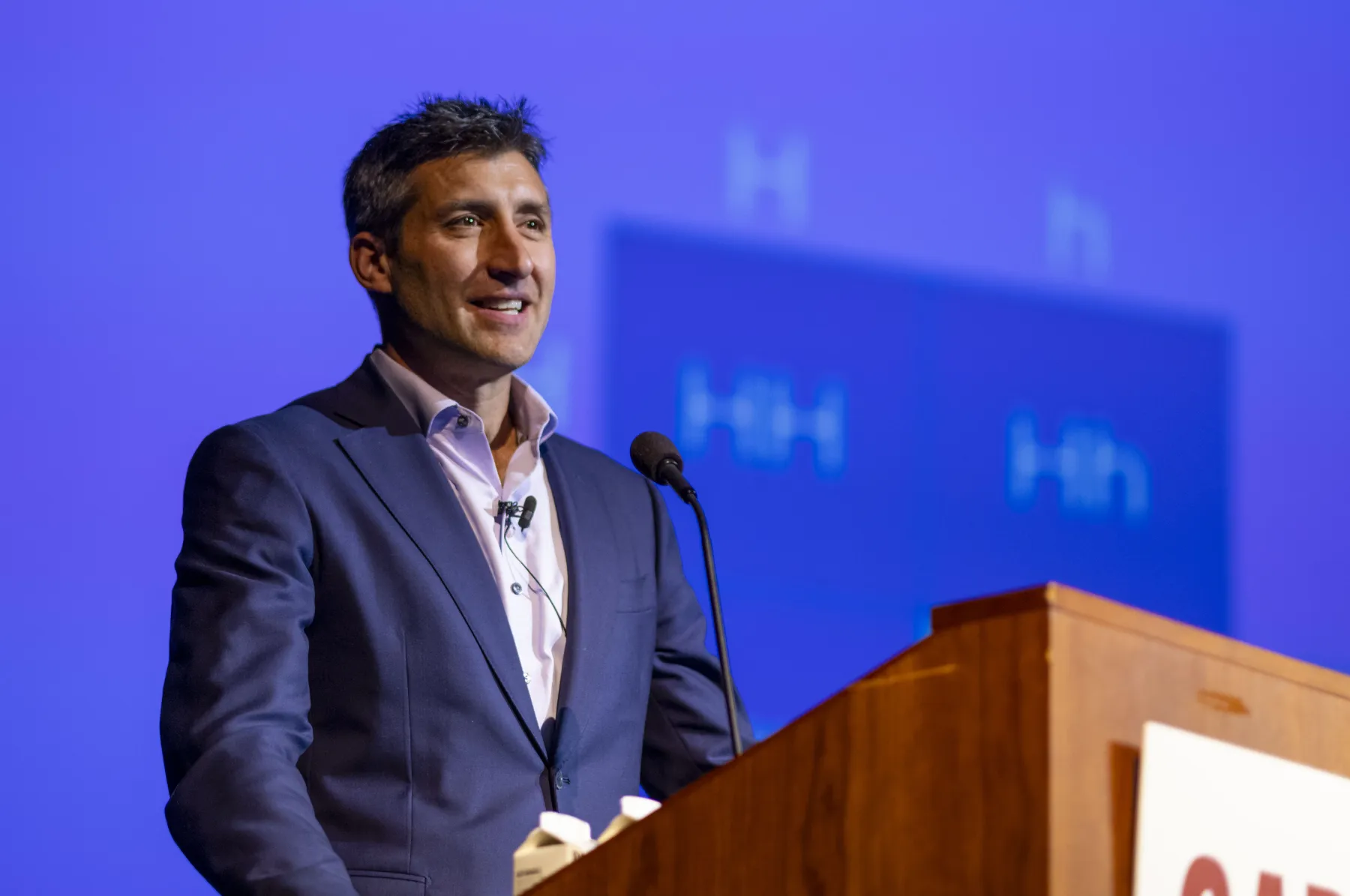 Matthew Goldstein in a navy suit speaks at the podium for the 2024 McCabe Lecture Series.