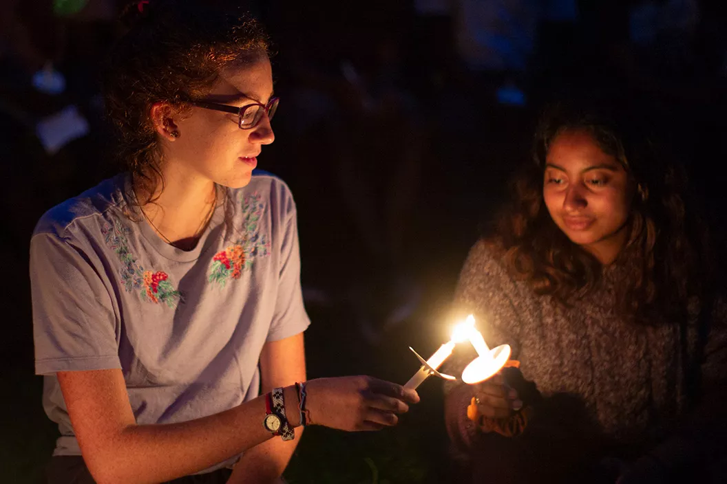 Students hold candles at First Collection