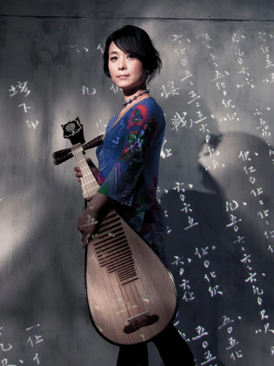 Wu Man standing, holding a pipa