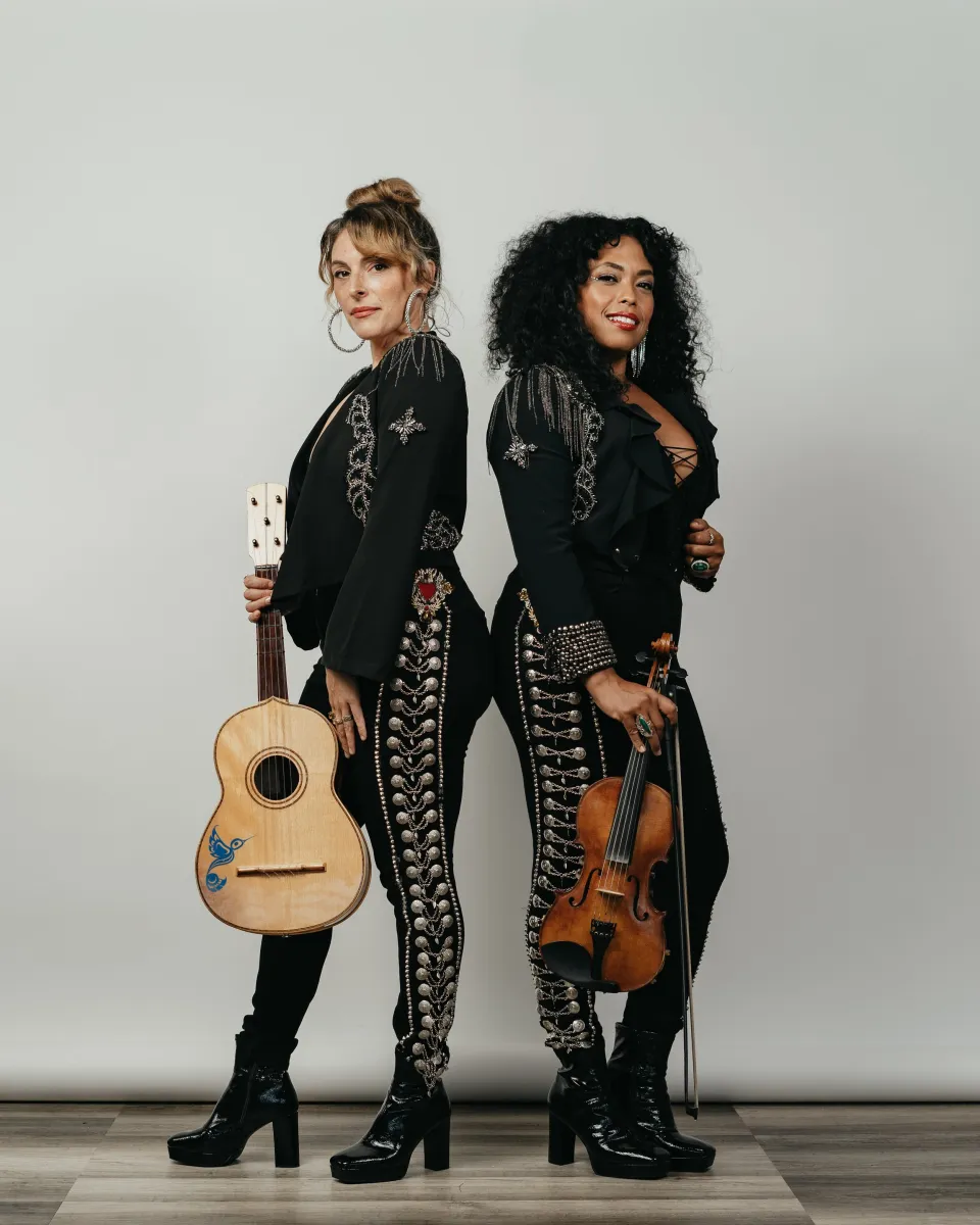 Guitarist and violinist standing back to back