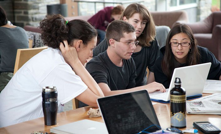 Students gather around a computer