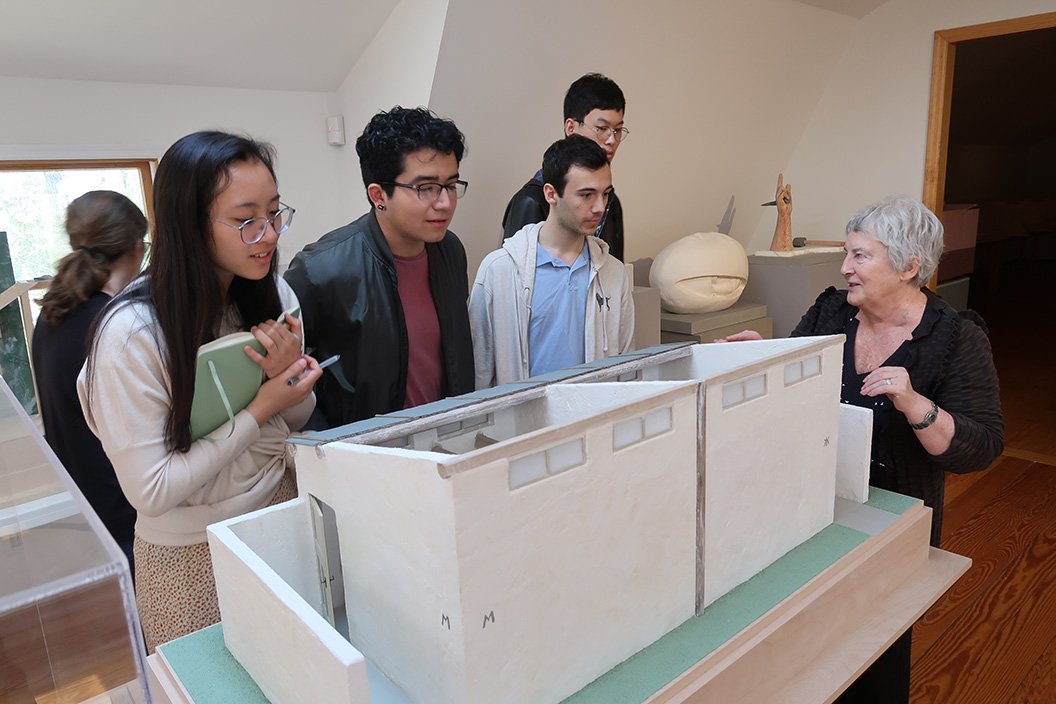 Woman shows students model of building