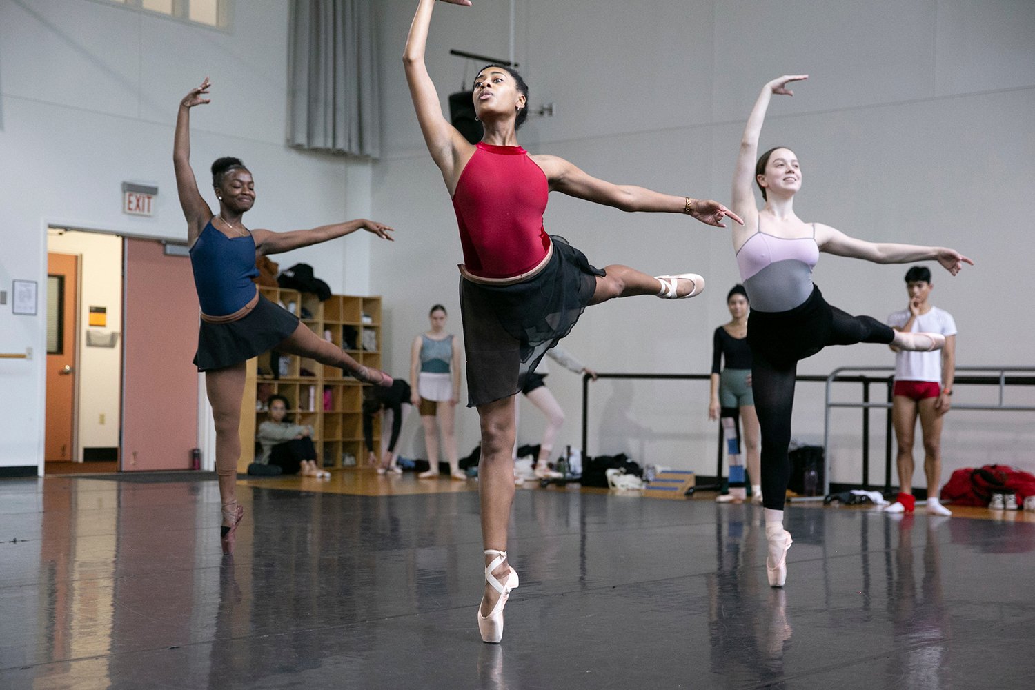 Three ballet dancers en pointe during class in studio