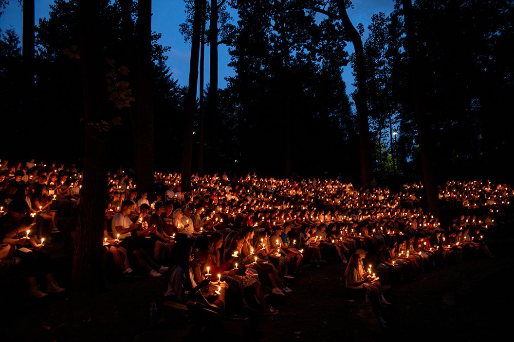 Wide shot of students holding candles at first collection