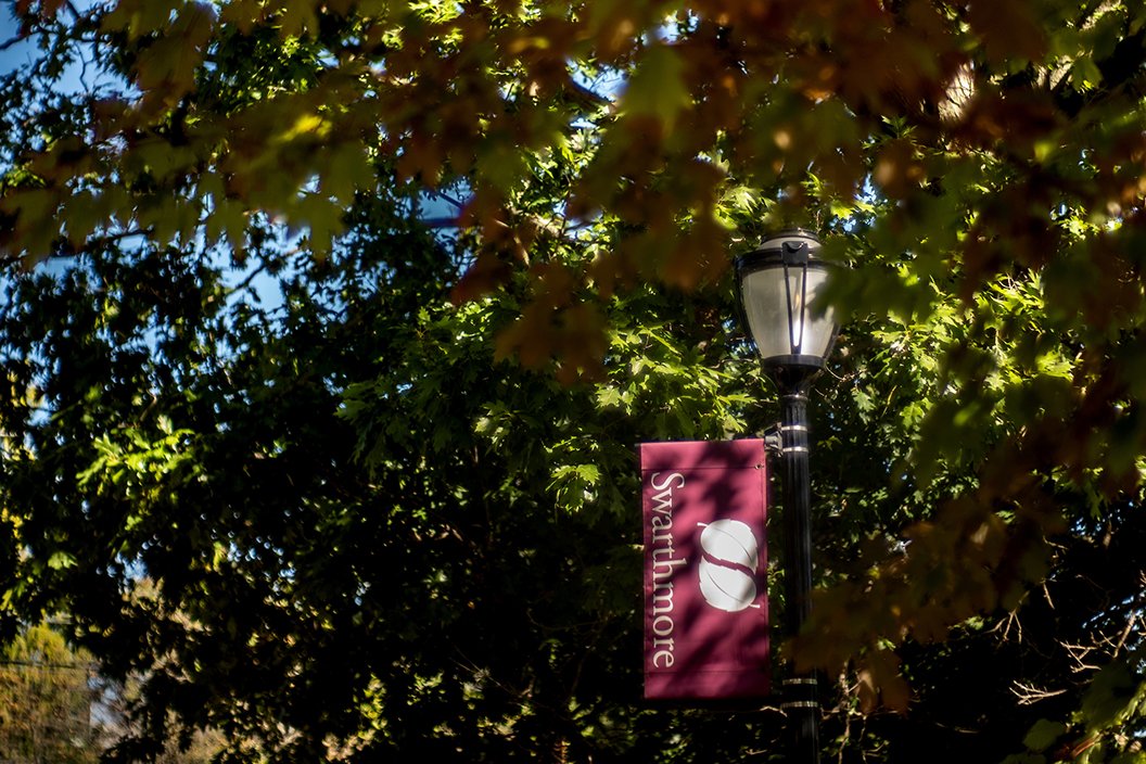 Swarthmore flag on lamp post underneath fall leaves