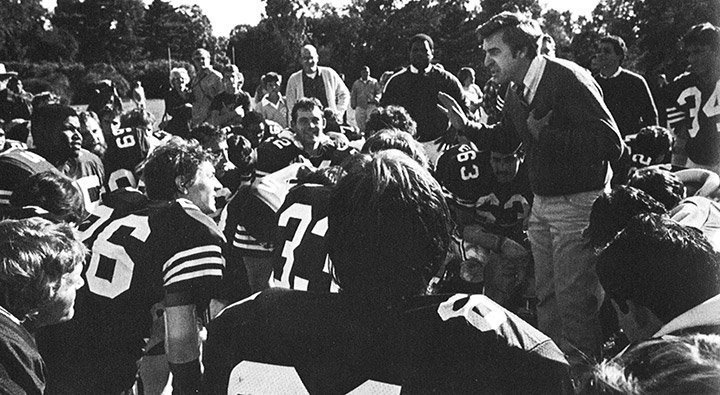 Coach Tom Lapinski huddles with the football team