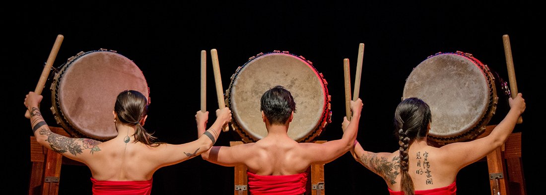 Three taiko drummers with back to camera