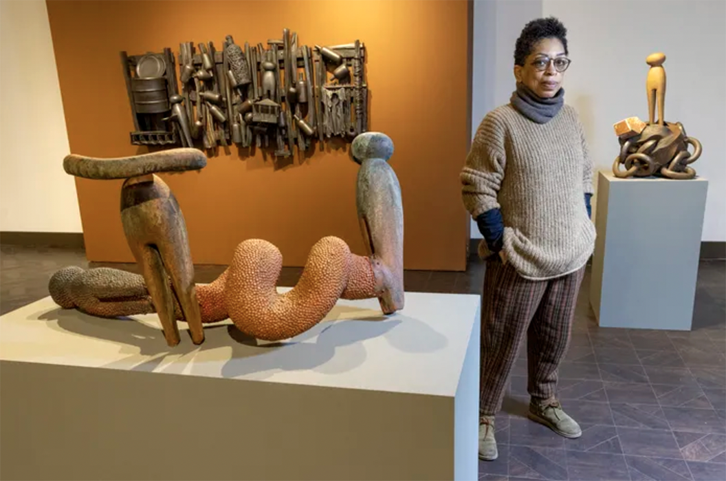 Syd Carpenter stands in Gallery with statues