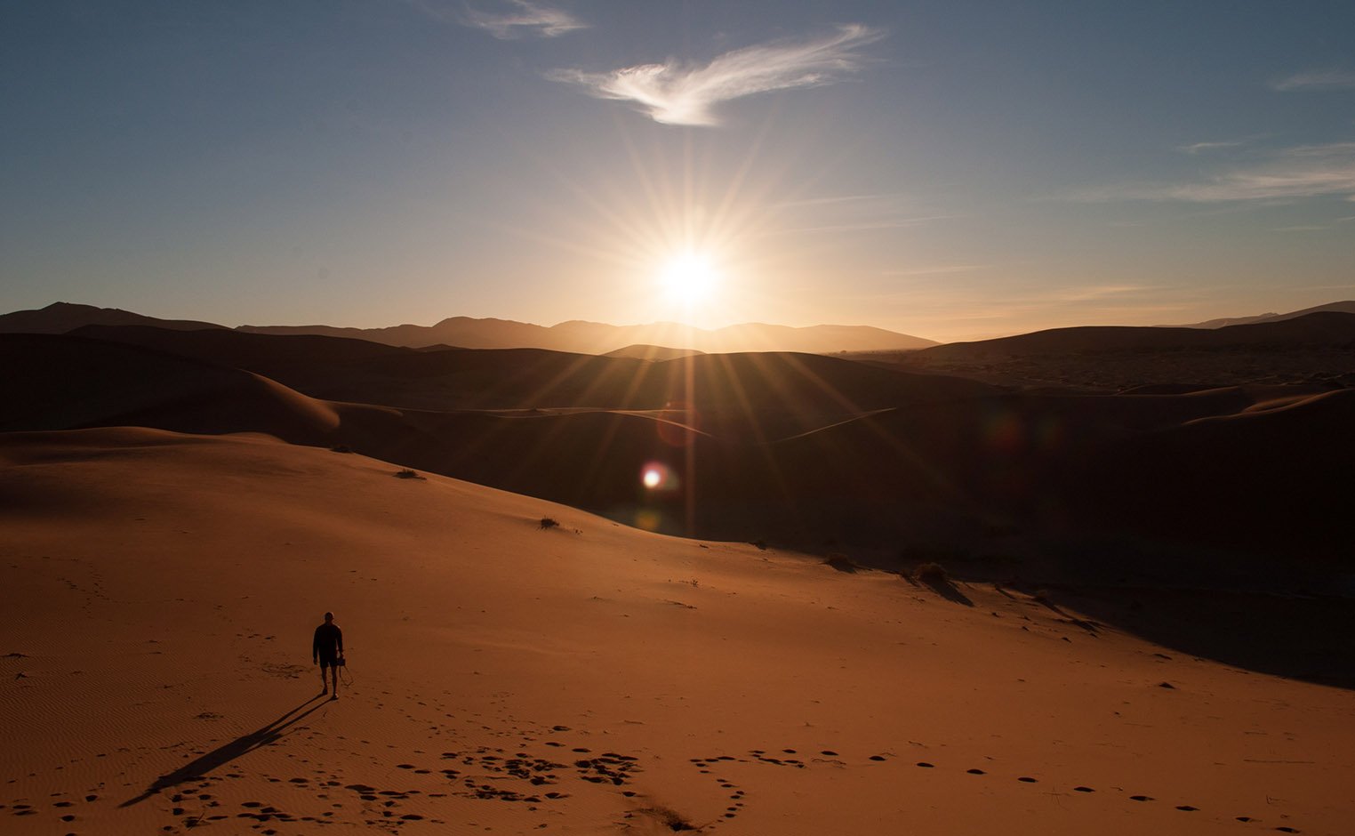 person walking in desert, dramatic lighting