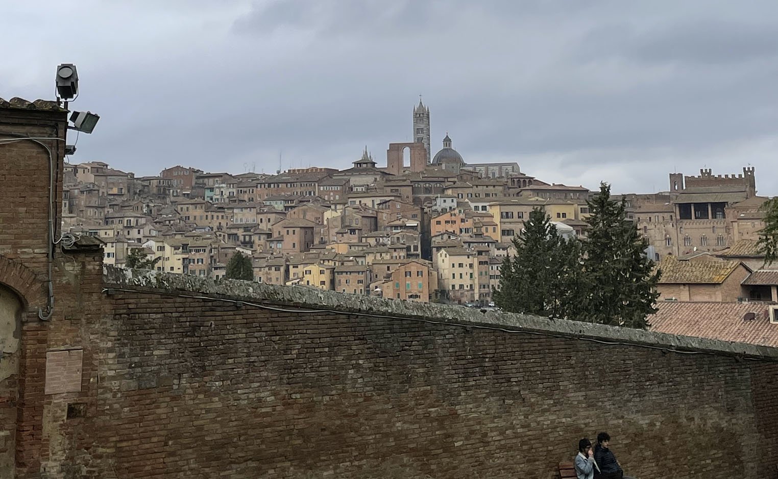 wall with rooftops and sky in Siena, Italy