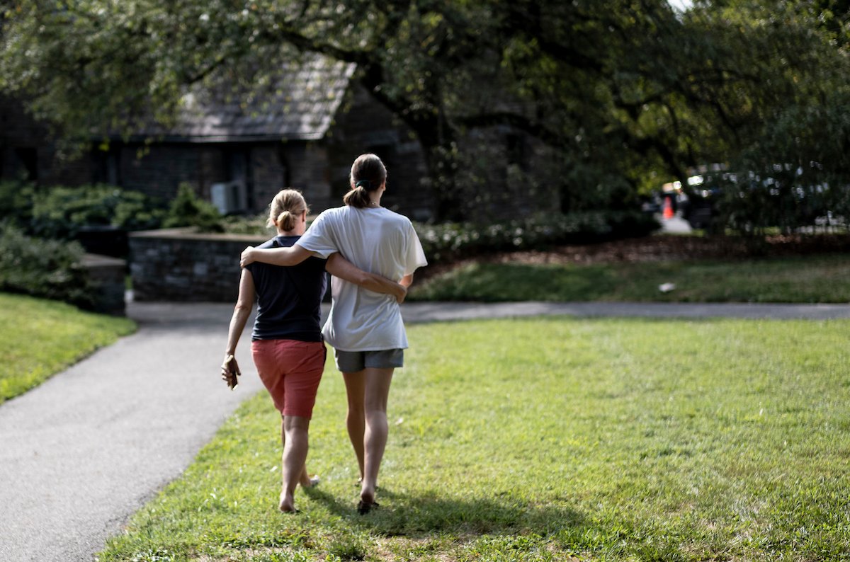 A parent and student walk together near Worth lawn. 