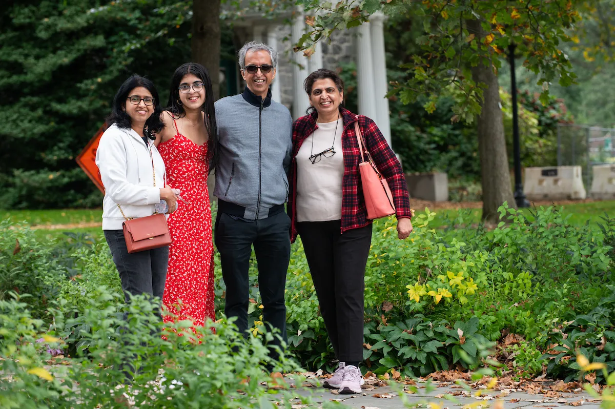 A family of four stands in front of Parrish Hall 