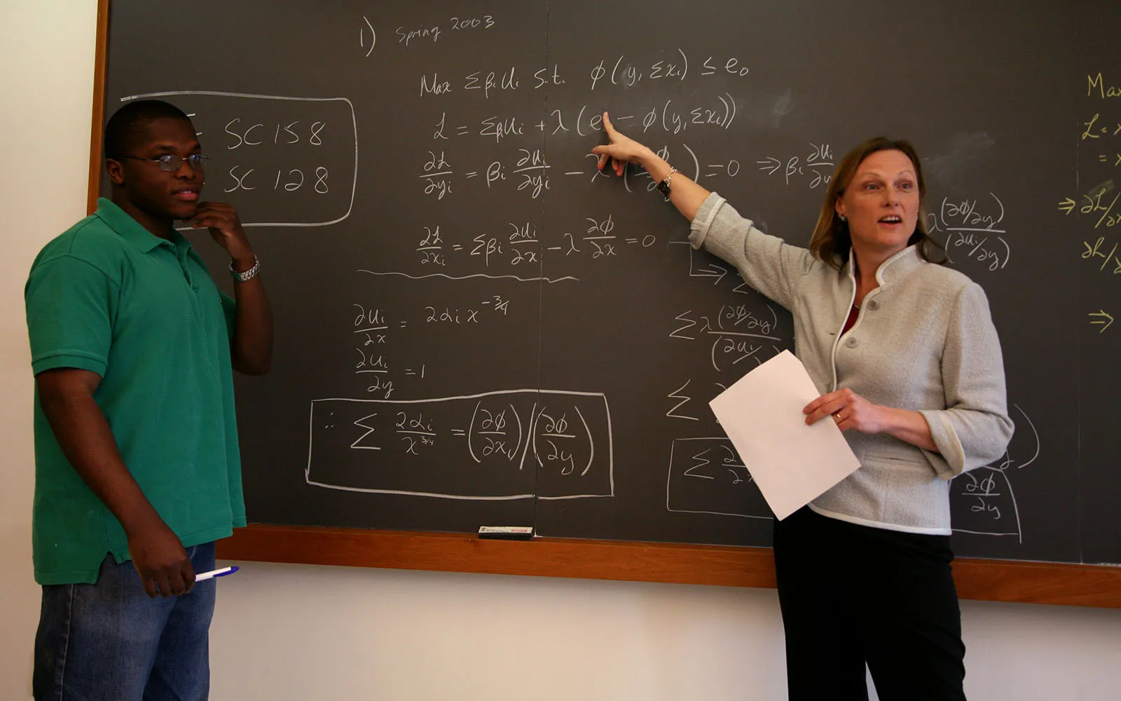 professor teaching in front of chalk board