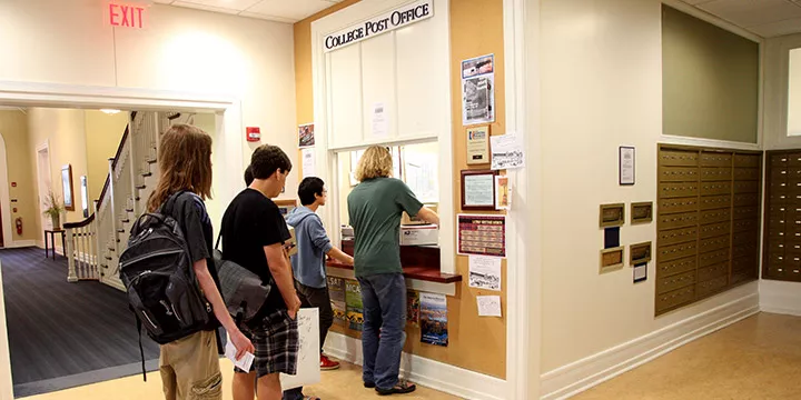 Students waiting in a line for their packages at post office package pick up window