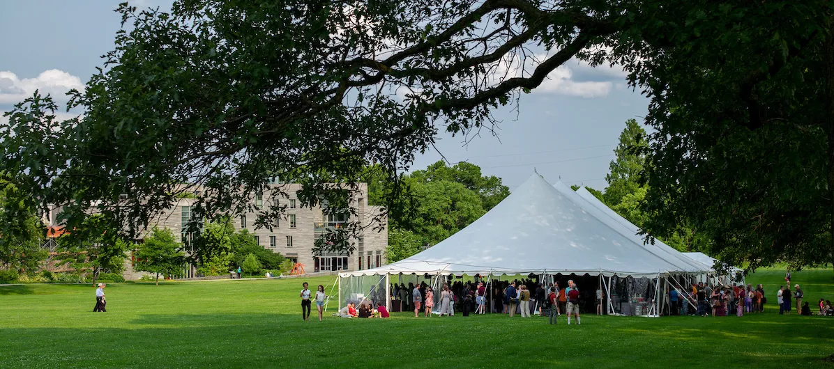 Alumni gather under a tent on Parrish Beach during Alumni Weekend 2019