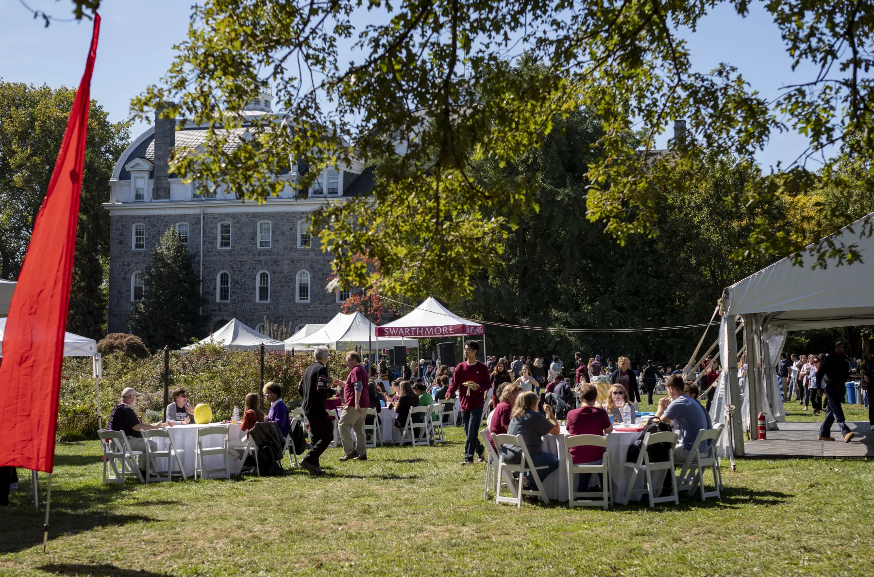 Swarthmore community members gathered outside under tents on a sunny day