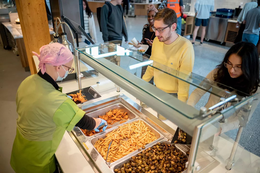 Students are served in line in dining center