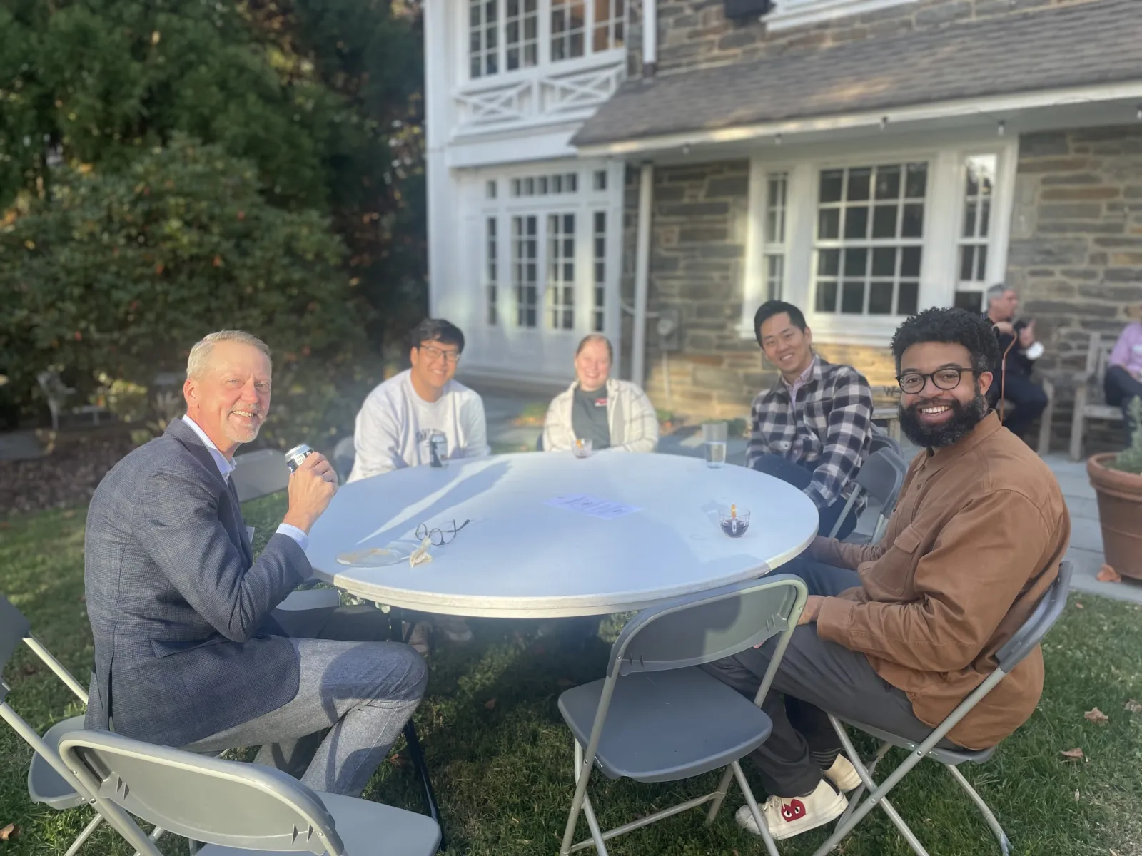 faculty and staff sit at a table outside
