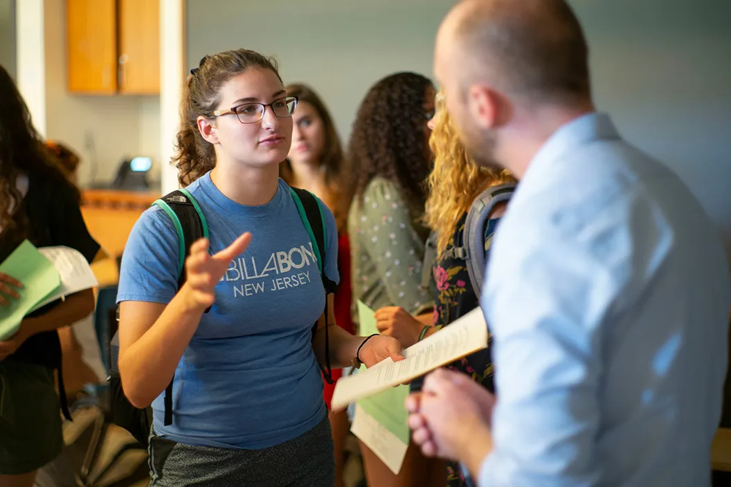 Student speaks to professor at academic fair