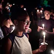 Student holds candle at First Collection 