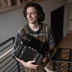 Quincy Ponvert on stairs with bandoneón in hands