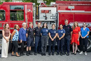 Group of people stand in front of fire truck