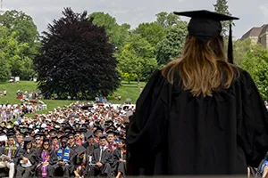 Person in commencement garb faces large crowd