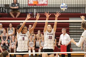 Emma Morgan-Bennett and Mehra den Braven trying to block across from volleyball net