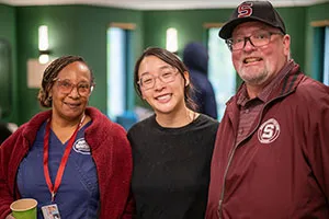 Three people pose in group photo at learning for life reception