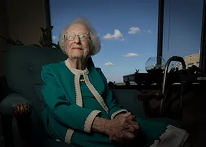 Nancy Grace Roman '46 sitting in front of a window at her home