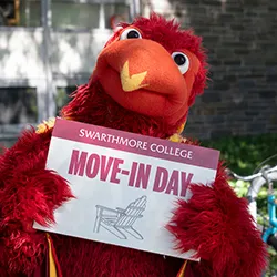 Phineas the Phoenix holds a sign for move-in day