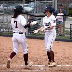Two softball players exchange high fives